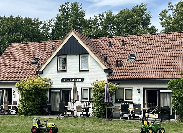 Modern kitchen in Koetshuis vacation home, De Koog, Texel, with wooden cabinets and views of green nature.