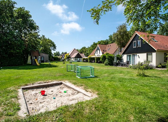 Modern kitchen in Koetshuis vacation home, De Koog, Texel, with wooden cabinets and views of green nature.