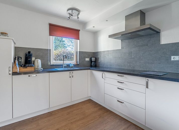 Gemuetliche Terrasse des Ferienhauses Kamperfoelie 97, De Koog, Texel, umgeben von viel Gruen auf den schoenen Watteninseln.