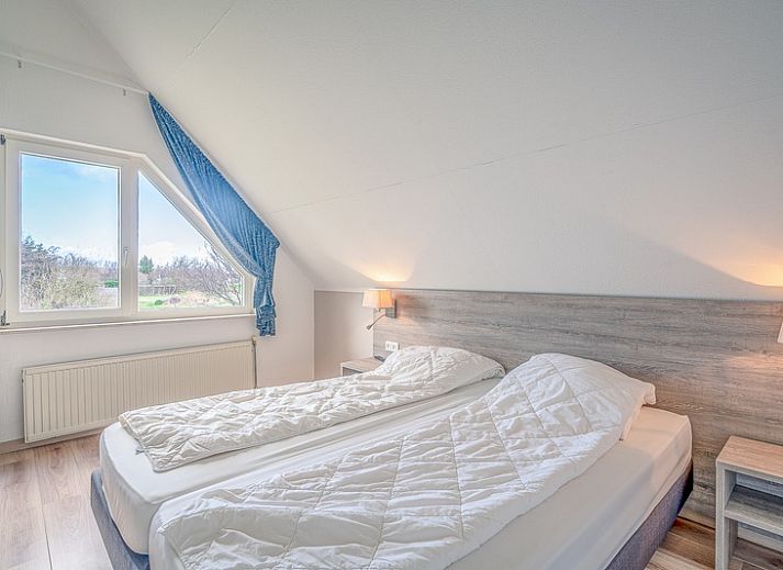 Sunny terrace at Holiday home Kamperfoelie 55 in De Koog Texel with comfortable deck chairs.