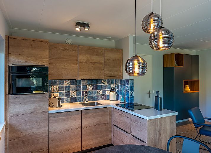 Cozy terrace at Zilte Bries vacation home, De Koog, Texel, overlooking green garden.