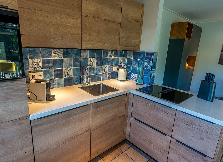 Cozy terrace at Zilte Bries vacation home, De Koog, Texel, overlooking green garden.