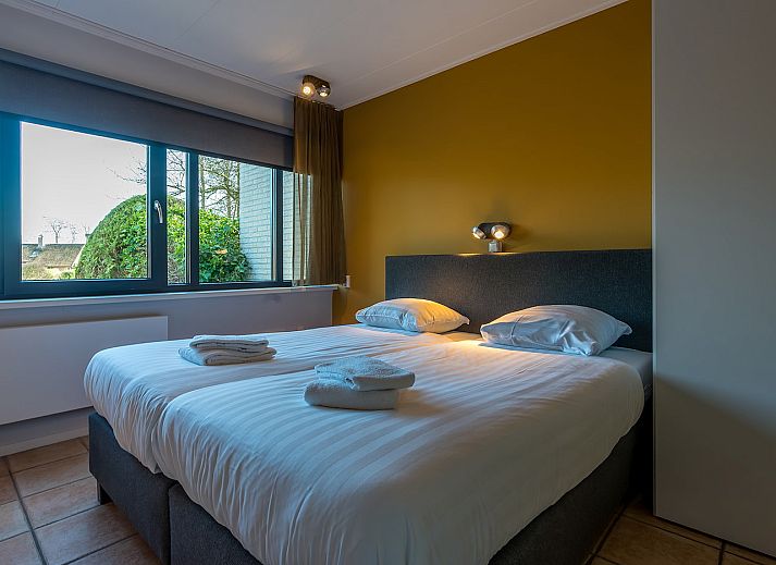 Cozy terrace at Zilte Bries vacation home, De Koog, Texel, overlooking green garden.