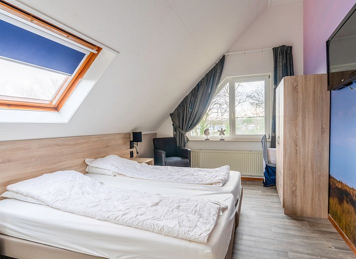 Spacious terrace at Holiday home Honeysuckle 45, De Koog, Texel, overlooking a green garden.