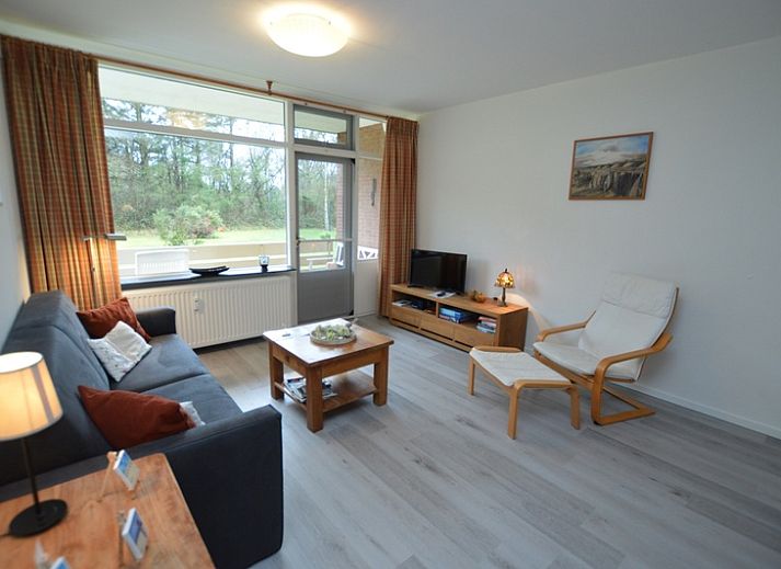 Cozy living room of Apartment Kerckeland 20 in De Koog, Texel with comfortable sitting area and dining area.