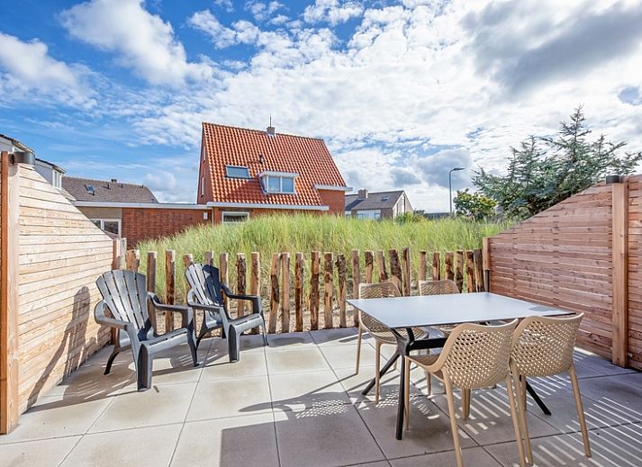 Cozy living room of De Duinroos in De Koog, Texel with comfortable sofas and lots of light.