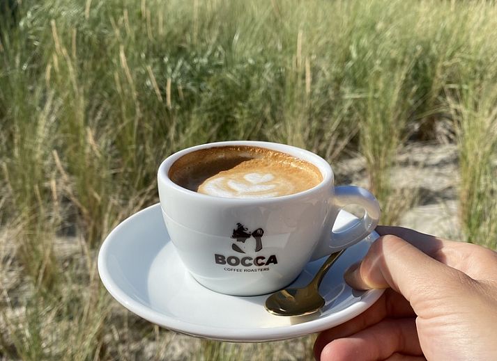 Cozy living room of De Duinroos in De Koog, Texel with comfortable sofas and lots of light.