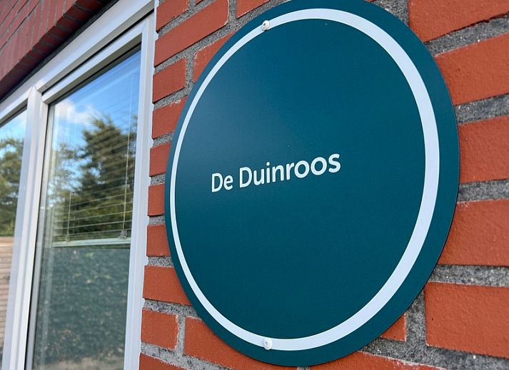 Stylish sitting area in De Duinroos vacation home, Texel, with modern furnishings and television.