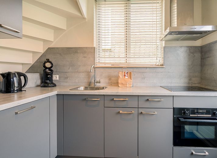 Cozy living room in De Bosruiter vacation home, De Koog Texel, with comfortable sofa and lots of natural light.
