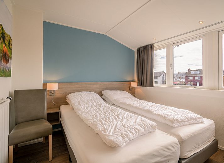 Cozy living room in De Bosruiter vacation home, De Koog Texel, with comfortable sofa and lots of natural light.