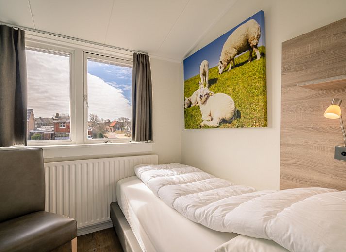 Cozy living room in De Bosruiter vacation home, De Koog Texel, with comfortable sofa and lots of natural light.