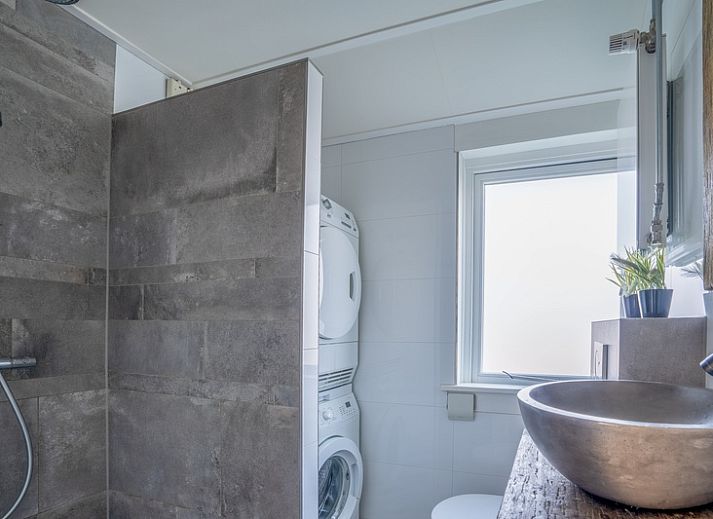 Cozy living room in De Bosruiter vacation home, De Koog Texel, with comfortable sofa and lots of natural light.