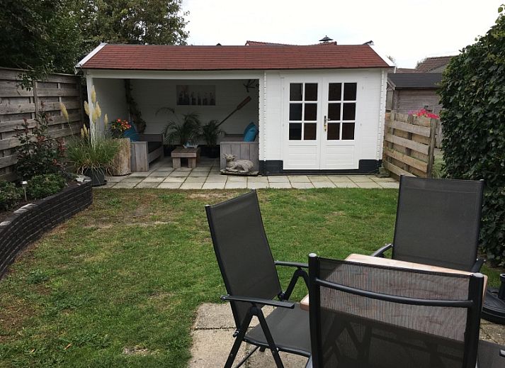 Gemuetliches Wohnzimmer des Ferienhauses Jutter in De Koog, Texel. Gemuetliche Sitzecke mit Blick auf die gruene Umgebung.