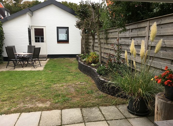 Gemuetliches Wohnzimmer des Ferienhauses Jutter in De Koog, Texel. Gemuetliche Sitzecke mit Blick auf die gruene Umgebung.