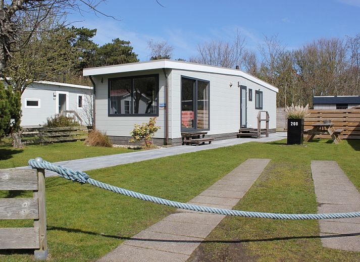 Das Chalet Bregkoog 208 in De Koog, Texel, bietet ein modernes Aeusseres mit grossen Fenstern und einer gruenen Umgebung.