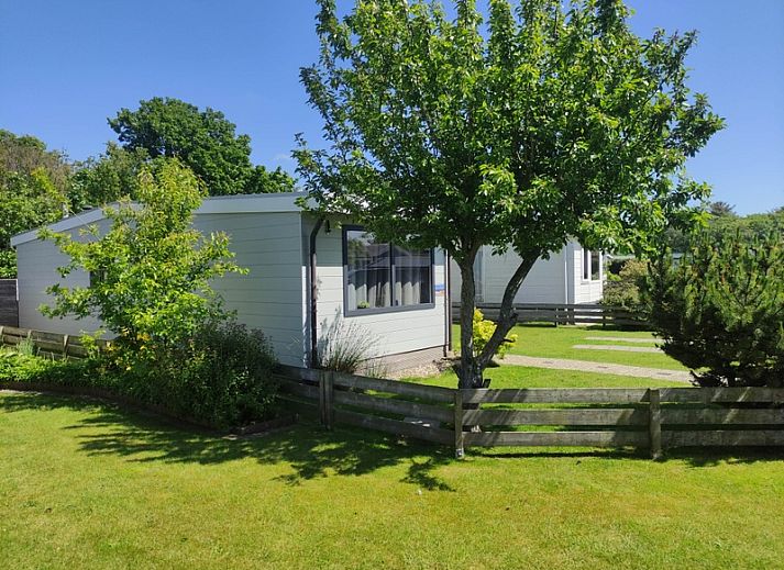 Das Chalet Bregkoog 208 in De Koog, Texel, bietet ein modernes Aeusseres mit grossen Fenstern und einer gruenen Umgebung.