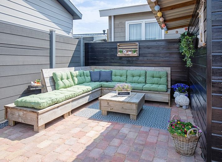 Vooraanzicht van Chalet Bregkoog 88, een vakantiewoning in De Koog, Texel met sfeervolle houten details.