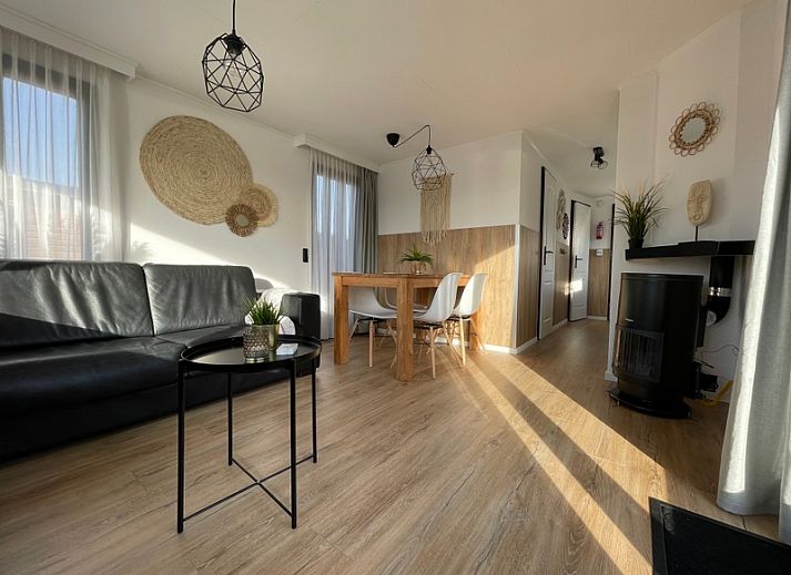 Chaletpark Bregkoog 253 in De Koog, Texel mit charmanter Holzfassade und einladender Terrasse, ideal fuer einen entspannten Urlaub.