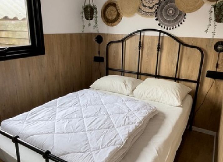 Chaletpark Bregkoog 253 in De Koog, Texel mit charmanter Holzfassade und einladender Terrasse, ideal fuer einen entspannten Urlaub.