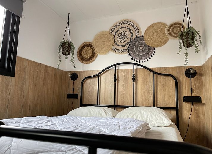 Chaletpark Bregkoog 253 in De Koog, Texel mit charmanter Holzfassade und einladender Terrasse, ideal fuer einen entspannten Urlaub.