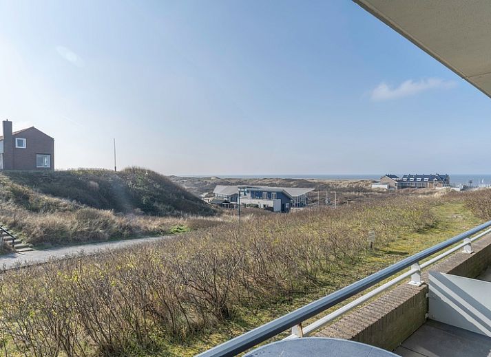Geraeumiges Wohnzimmer der Ferienwohnung Juliana 046 Insel- und Meerblick, De Koog, Texel mit moderner Einrichtung und Blick auf die Natur.