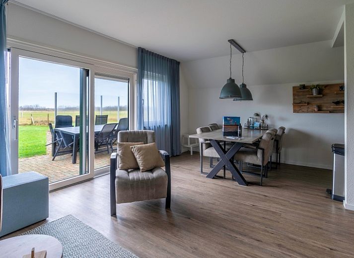 Gemuetliches Ferienhaus Nieuwlanderweg 77 in De Koog, Texel, mit gruener Umgebung und sonniger Terrasse fuer einen perfekten Urlaub auf den Watteninseln.