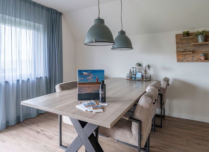 Gemuetliches Ferienhaus Nieuwlanderweg 77 in De Koog, Texel, mit gruener Umgebung und sonniger Terrasse fuer einen perfekten Urlaub auf den Watteninseln.