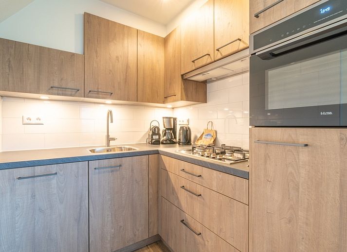 Gemuetliches Ferienhaus Nieuwlanderweg 77 in De Koog, Texel, mit gruener Umgebung und sonniger Terrasse fuer einen perfekten Urlaub auf den Watteninseln.