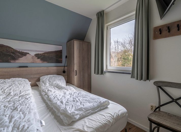 Gemuetliches Ferienhaus Nieuwlanderweg 77 in De Koog, Texel, mit gruener Umgebung und sonniger Terrasse fuer einen perfekten Urlaub auf den Watteninseln.