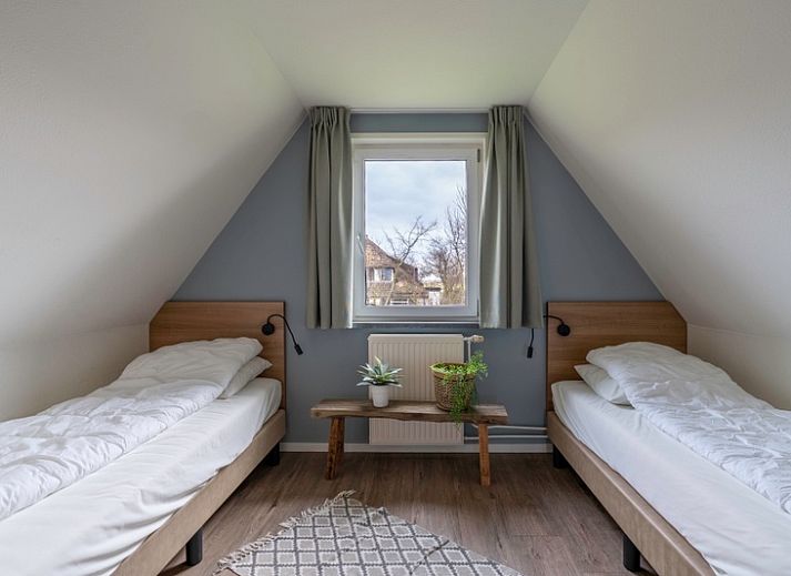 Gemuetliches Ferienhaus Nieuwlanderweg 77 in De Koog, Texel, mit gruener Umgebung und sonniger Terrasse fuer einen perfekten Urlaub auf den Watteninseln.