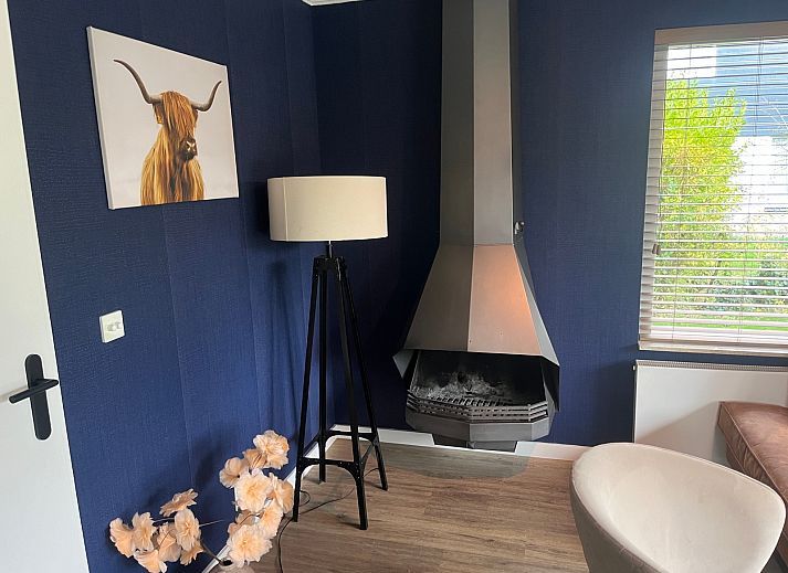 Stijlvolle woonkamer van De Duinven in De Koog, Texel, met uitzicht op de tuin, perfect voor familiebijeenkomsten.