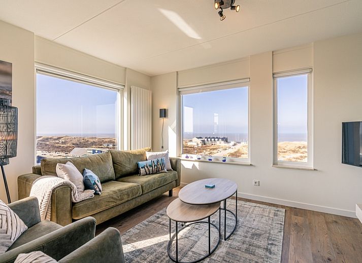 Wohnung Juliana 150 Zeezicht in De Koog Texel, helles Wohnzimmer mit Panoramablick auf Meer und Duenen.