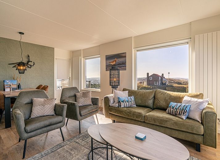 Wohnung Juliana 150 Zeezicht in De Koog Texel, helles Wohnzimmer mit Panoramablick auf Meer und Duenen.