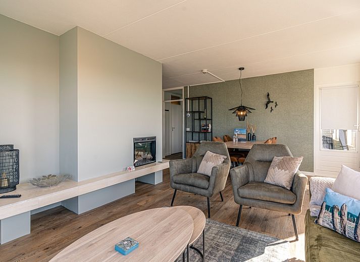 Wohnung Juliana 150 Zeezicht in De Koog Texel, helles Wohnzimmer mit Panoramablick auf Meer und Duenen.