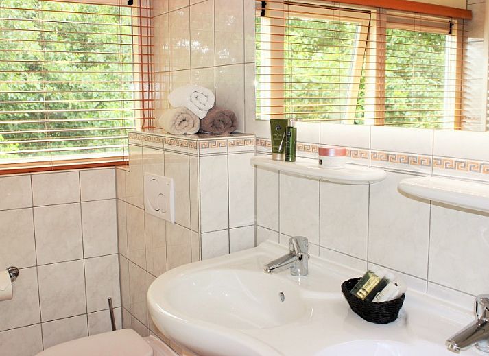 Dining area and kitchen in 6p.thatched vacation home Eldorado Texel, De Koog, with stylish lighting.