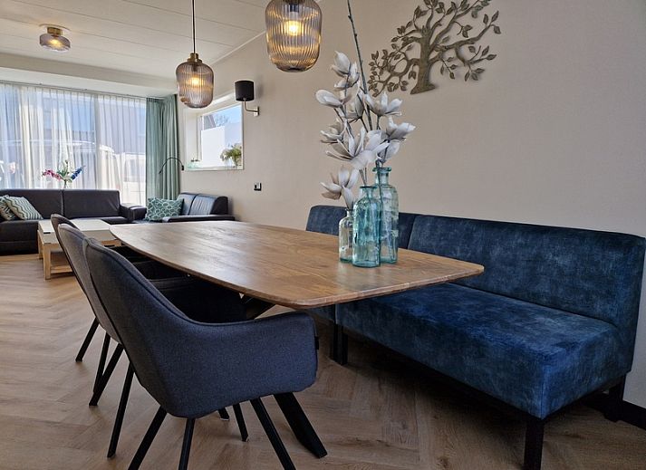 Cozy dining room in Holiday home Duinzee Texel in De Koog with wooden table and modern lighting.