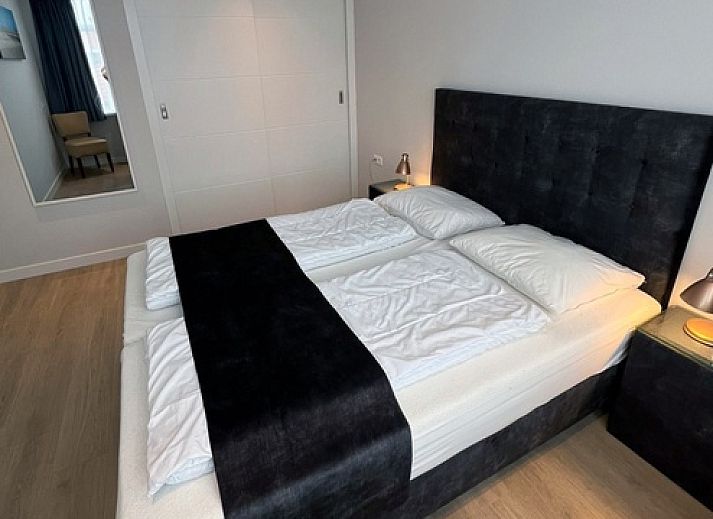 Cozy dining room in Holiday home Duinzee Texel in De Koog with wooden table and modern lighting.