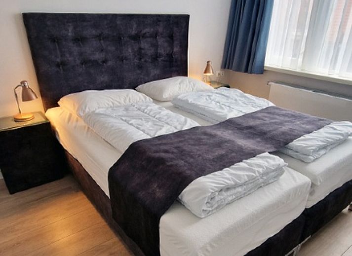 Cozy dining room in Holiday home Duinzee Texel in De Koog with wooden table and modern lighting.