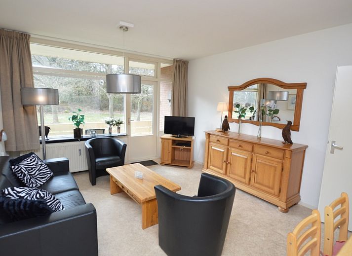 Gemuetliches Wohnzimmer im Appartement Kerckeland 28, De Koog, Texel mit bequemer Sitzecke und Blick auf die Natur.