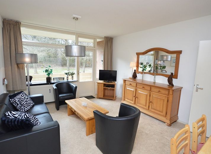 Gemuetliches Wohnzimmer im Appartement Kerckeland 28, De Koog, Texel mit bequemer Sitzecke und Blick auf die Natur.