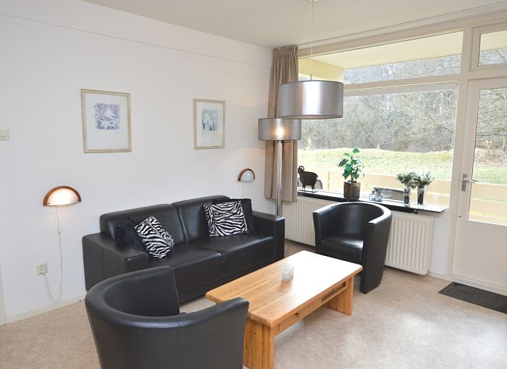 Gemuetliches Wohnzimmer im Appartement Kerckeland 28, De Koog, Texel mit bequemer Sitzecke und Blick auf die Natur.