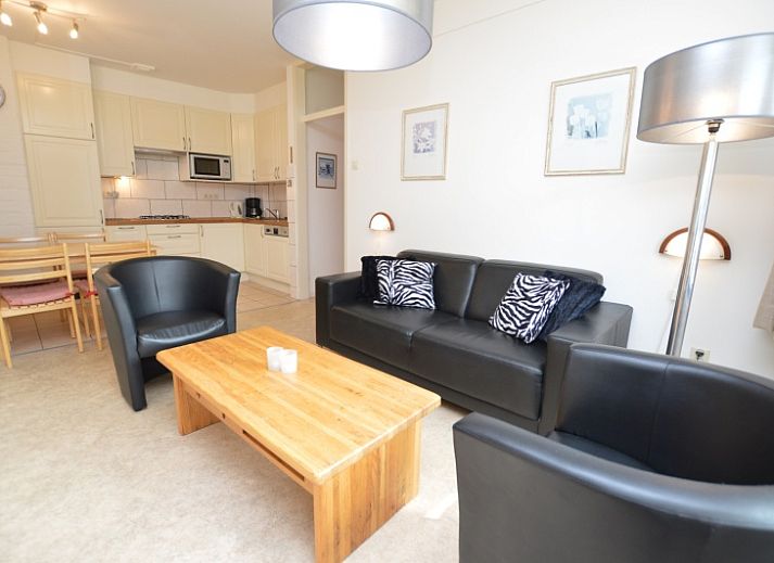 Gemuetliches Wohnzimmer im Appartement Kerckeland 28, De Koog, Texel mit bequemer Sitzecke und Blick auf die Natur.