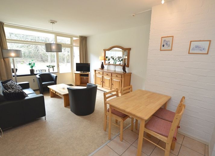 Gemuetliches Wohnzimmer im Appartement Kerckeland 28, De Koog, Texel mit bequemer Sitzecke und Blick auf die Natur.