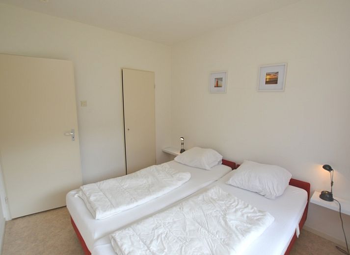 Helles Wohnzimmer des Appartements Kerckeland 28, De Koog, Texel mit modernen Moebeln und grossen Fenstern.