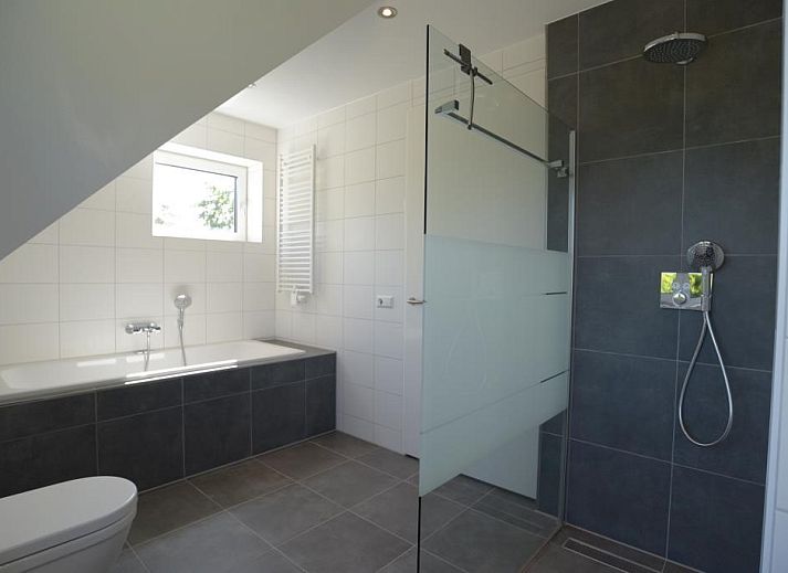 Gemuetliche Sitzecke im Ferienhaus 06 - Razende Bol - Kleingartenanlage, De Koog, Texel, mit bunten Stuehlen.