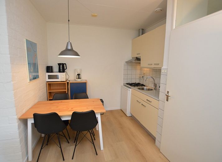 Spacious interior of Apartment Kerckeland 126 in De Koog, Texel, with dining area and view of the greenery.