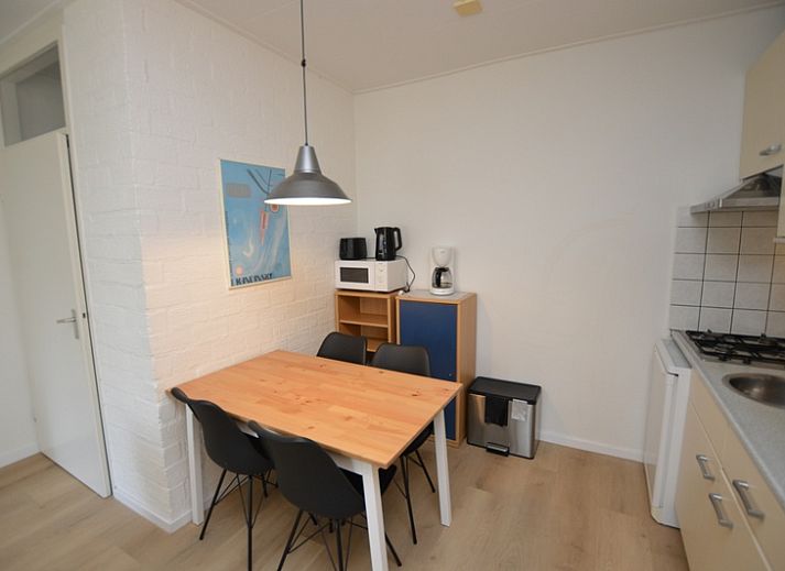 Spacious interior of Apartment Kerckeland 126 in De Koog, Texel, with dining area and view of the greenery.