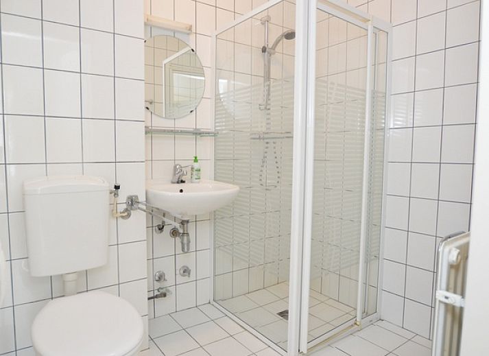 Spacious interior of Apartment Kerckeland 126 in De Koog, Texel, with dining area and view of the greenery.
