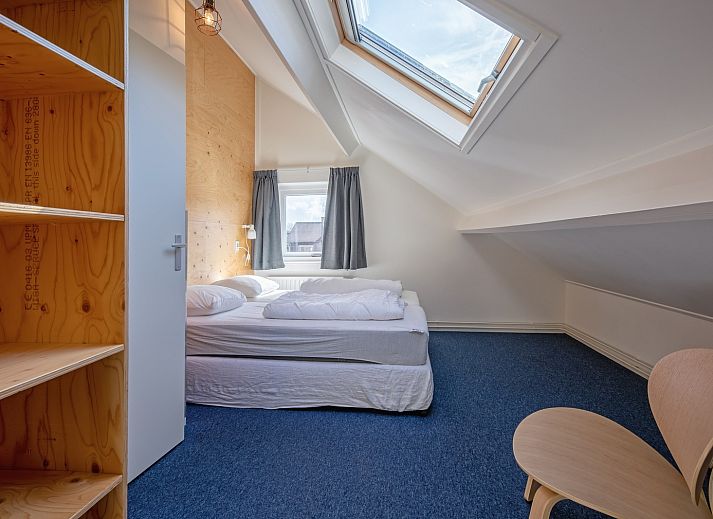 Sunny terrace with wooden seating at 32a Castor vacation home, De Koog, Texel.
