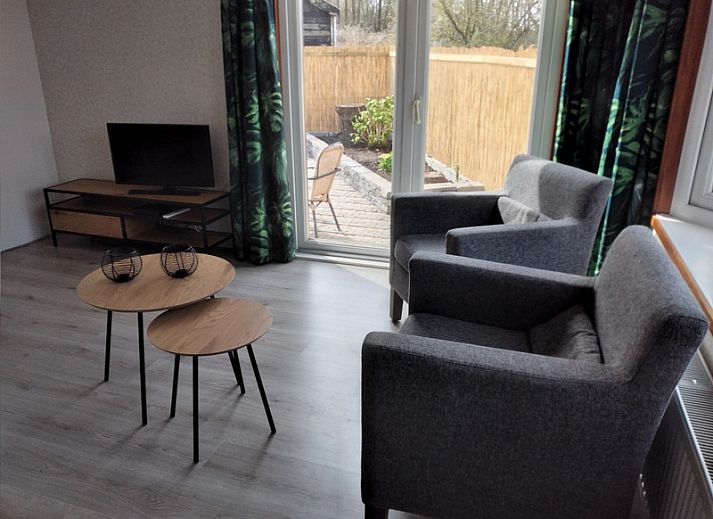 Veranda of Chalet Out and Home in De Koog, Texel, with wooden fence and parasol.